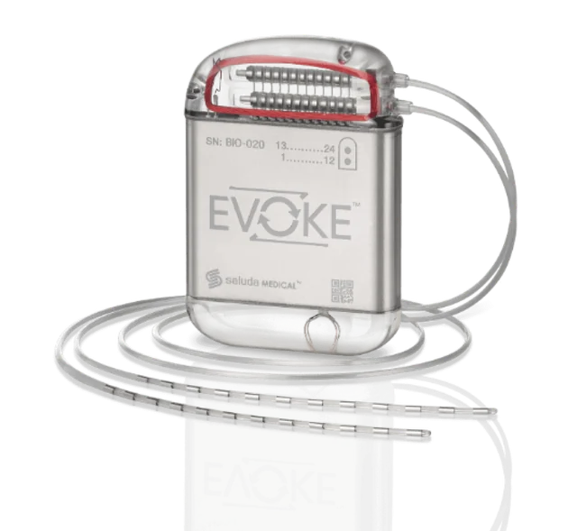 Evoke pulse generator with two coiled leads whose metal ring contacts extend across the foreground.
