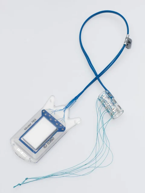 Isolated ActiGait demonstration implant with receiver, cable and transparent nerve cuff showing individual electrodes, photographed for the Science Museum Group collection.